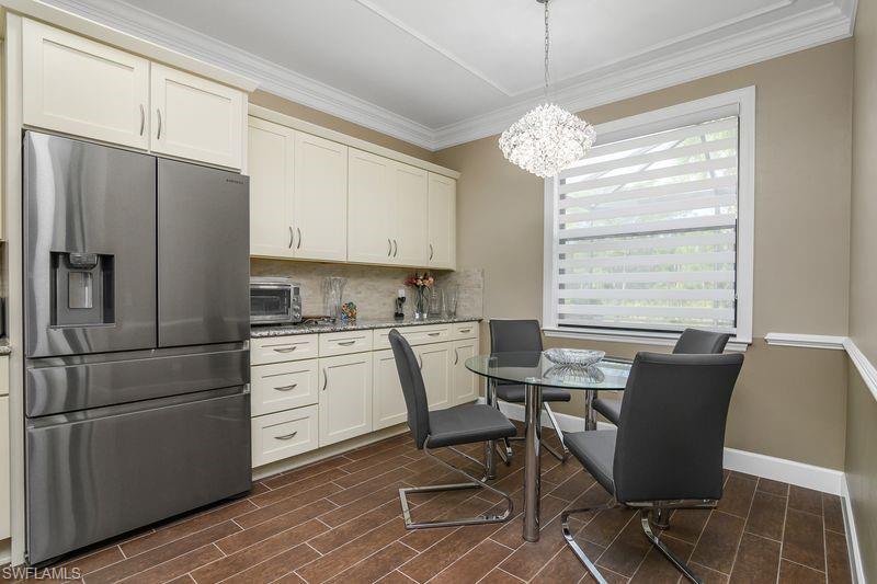 16309 Winfield Lane Naples, FL 34110 - Photo 10 of 36 a kitchen with a refrigerator a table and chairs in it