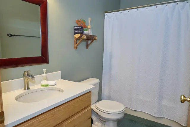a view of a hallway with wooden floor and a livingroom