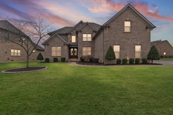 a front view of a house with a garden and plants