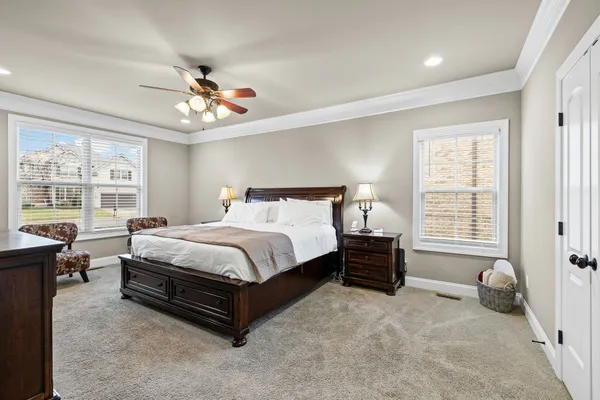 a spacious bedroom with a bed and a chandelier