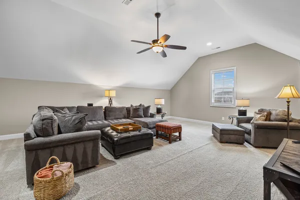 a living room with furniture and a ceiling fan