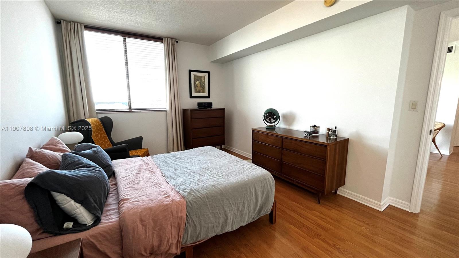 4242 Northwest 2nd Street, Unit 703 Miami, FL 33126 - Photo 13 of 25 a bedroom with a bed and wooden floor