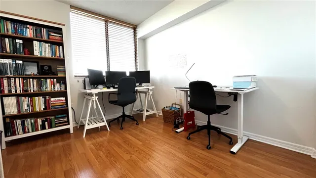 a view of a workspace with furniture and a bookshelf
