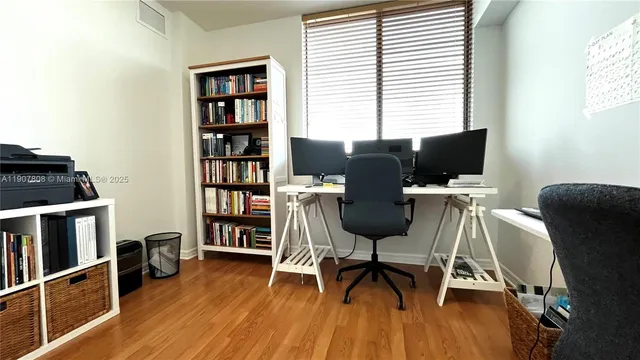 a view of a workspace with furniture and a window