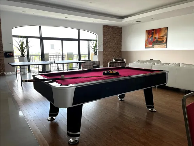 a room with pool table and windows