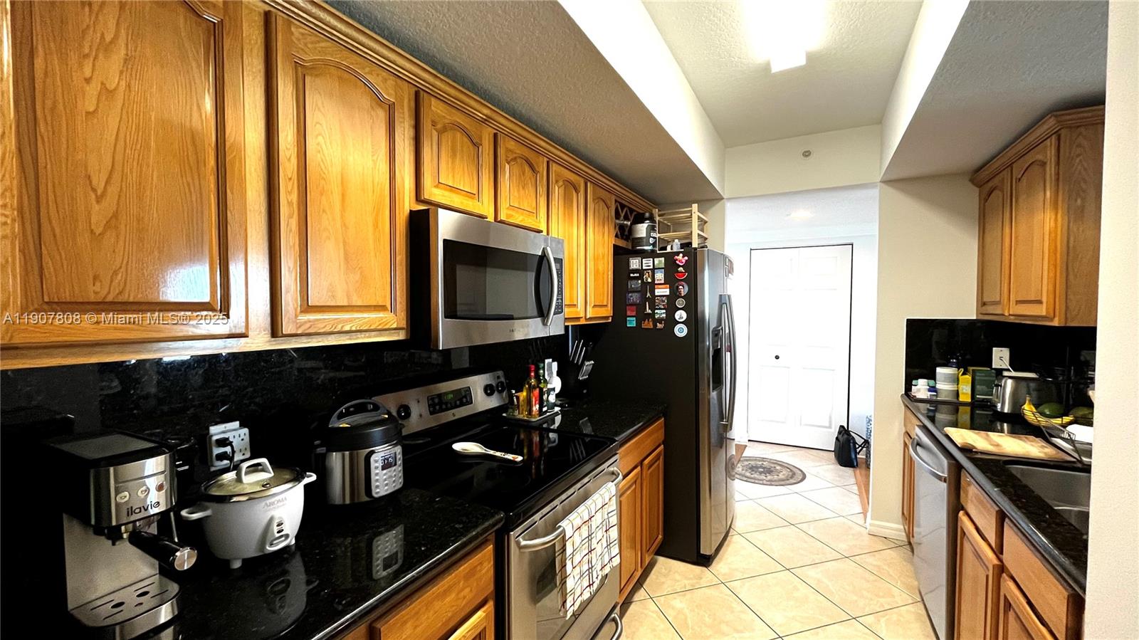 4242 Northwest 2nd Street, Unit 703 Miami, FL 33126 - Photo 4 of 25 a kitchen with a sink appliances and cabinets