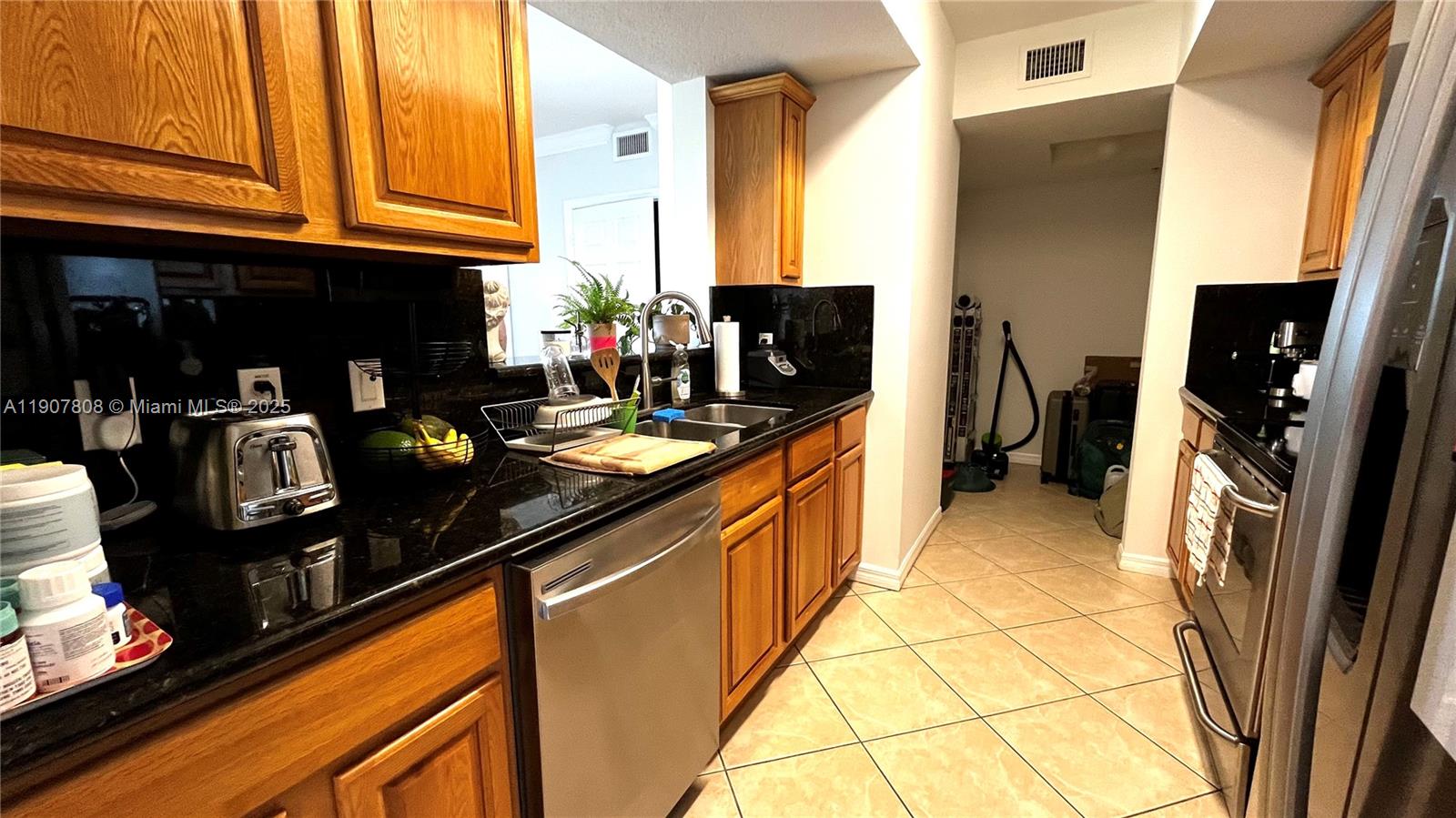 4242 Northwest 2nd Street, Unit 703 Miami, FL 33126 - Photo 5 of 25 a kitchen with granite countertop a sink stove and cabinets