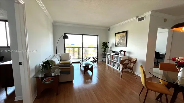 a living room with furniture floor to ceiling window and wooden floor