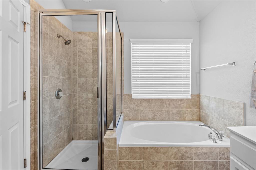 235 Limerick Road Buda, TX 78610 - Photo 9 of 11 Bathroom with a stall shower, vanity, and a bath