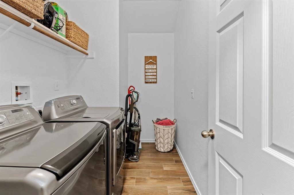 235 Limerick Road Buda, TX 78610 - Photo 10 of 11 Laundry area with wood finish floors and washing machine and dryer