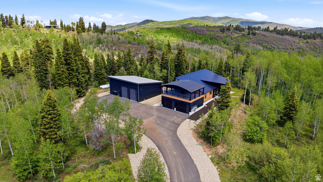 1000 West Upper Cove Road Park City, UT 84098 - Photo 61 of 63 Contemporary residence featuring a dark-toned exterior with wood accents and a curved balcony, situated on a sloped lot