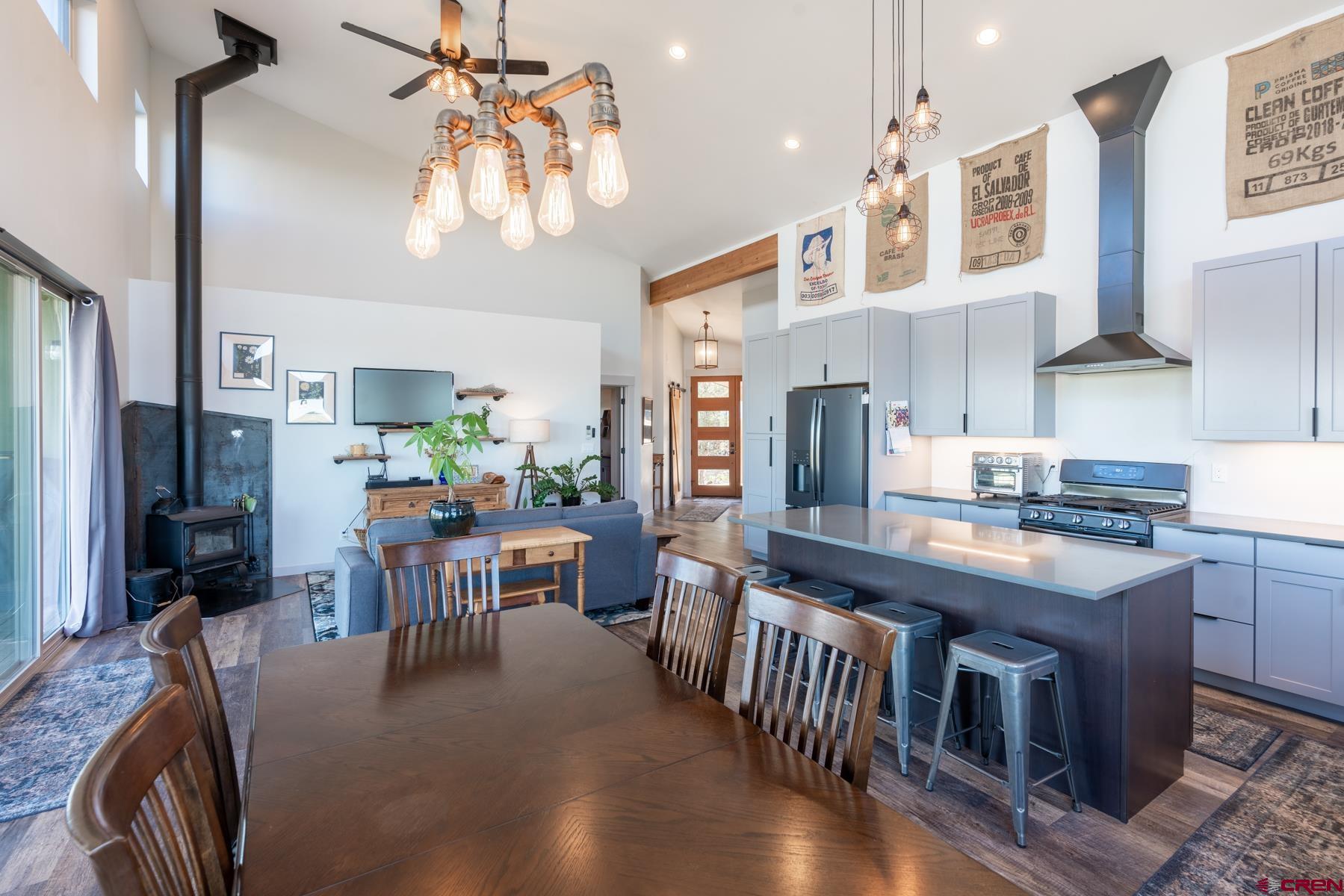 68 Cody Road Durango, CO 81303 - Photo 6 of 35 a kitchen with stainless steel appliances kitchen island granite countertop a table chairs in it and wooden floors