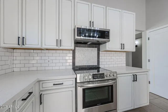 a kitchen with granite countertop white cabinets and white appliances