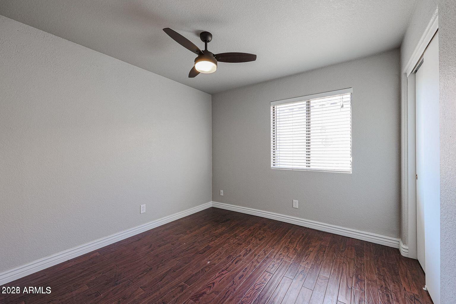 2134 East Robin Lane Phoenix, AZ 85024 - Photo 14 of 24 an empty room with wooden floor and windows