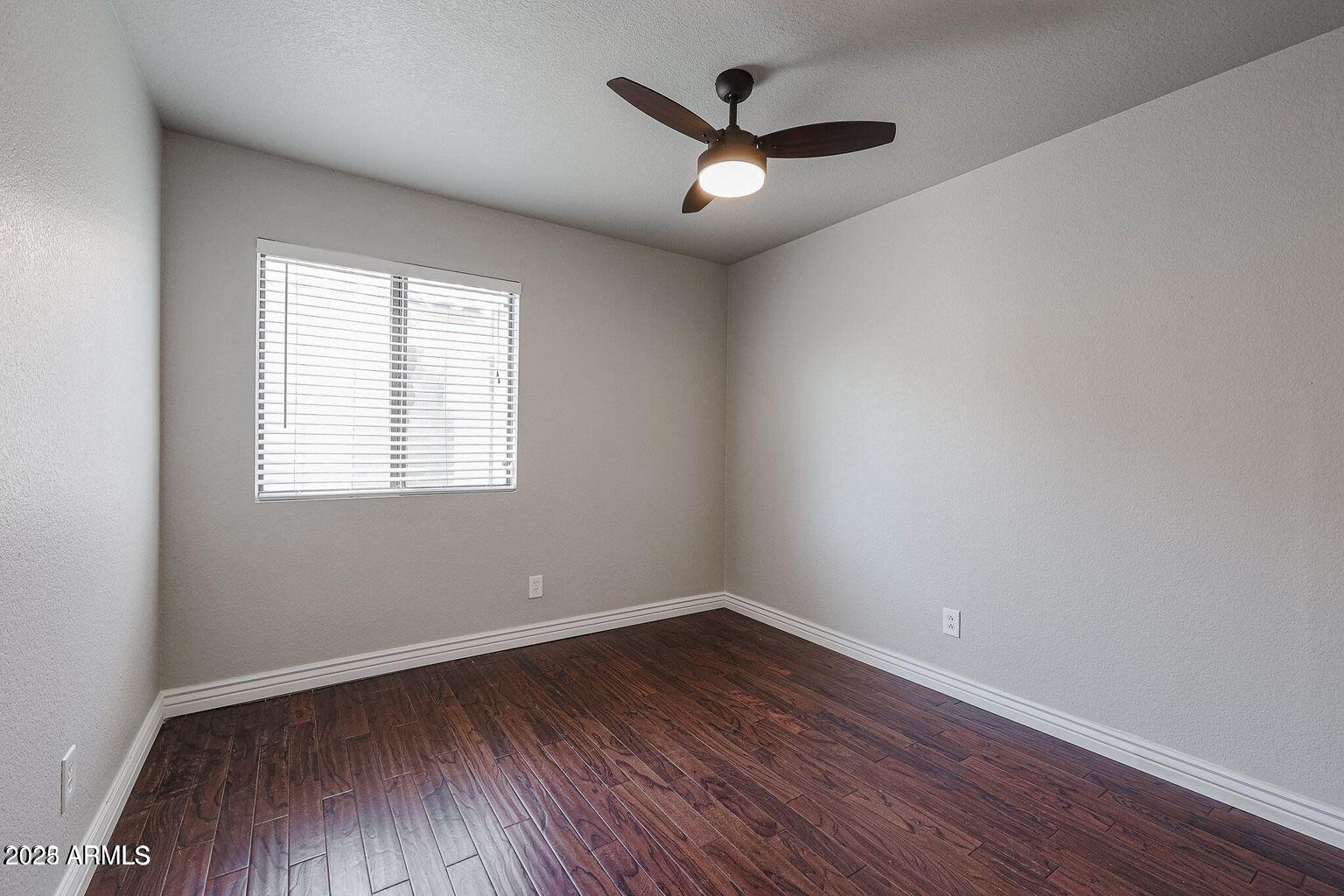2134 East Robin Lane Phoenix, AZ 85024 - Photo 16 of 24 an empty room with wooden floor and windows