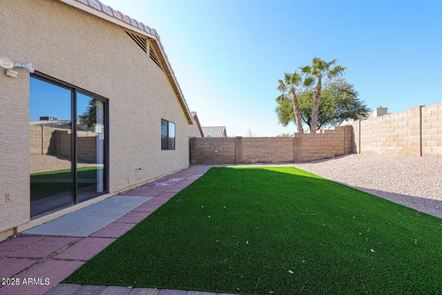 a view of an house with backyard and a tree
