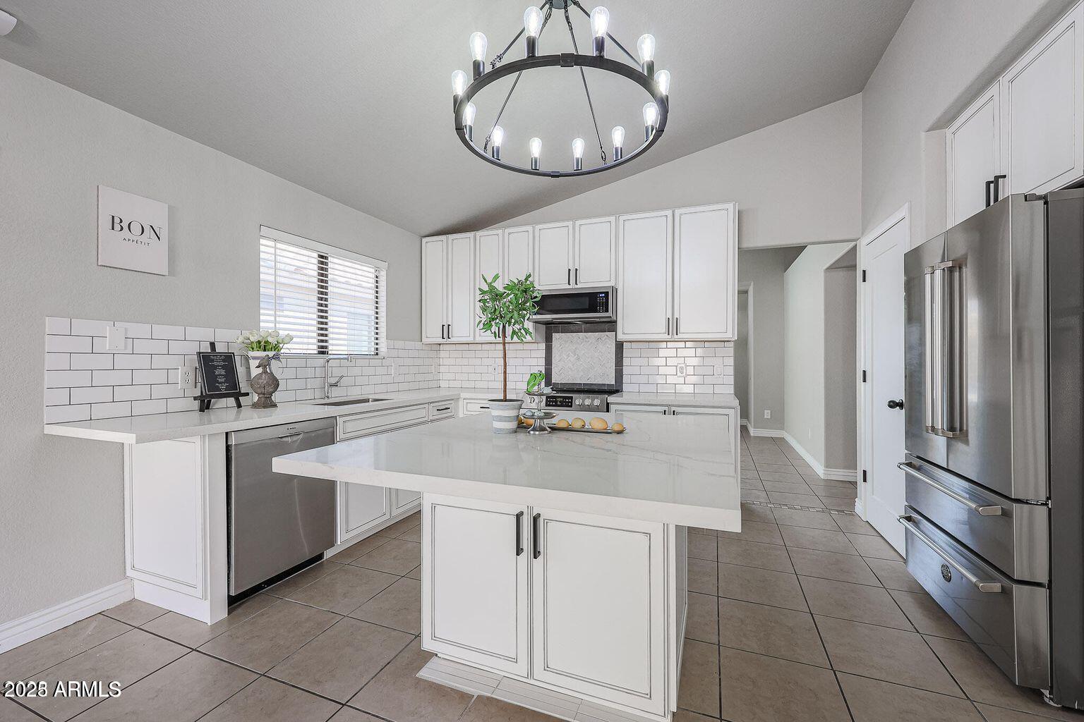 2134 East Robin Lane Phoenix, AZ 85024 - Photo 8 of 24 a kitchen with kitchen island granite countertop stainless steel appliances a sink stove and refrigerator