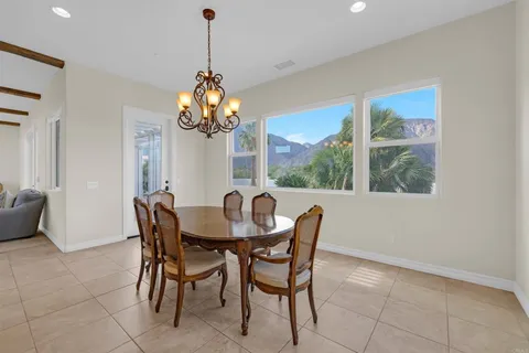 a dining room filled chandelier and wooden floor