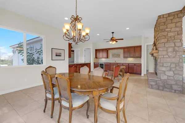 a kitchen with stainless steel appliances granite countertop a table chairs sink and cabinets