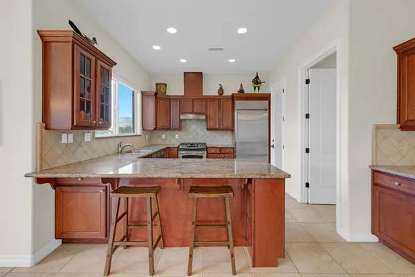 a kitchen with stainless steel appliances granite countertop a stove a sink and a microwave