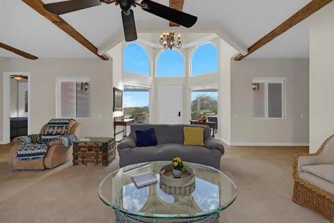 a living room with furniture chandelier and a view of kitchen