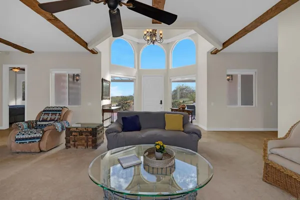a living room with furniture chandelier and a view of kitchen