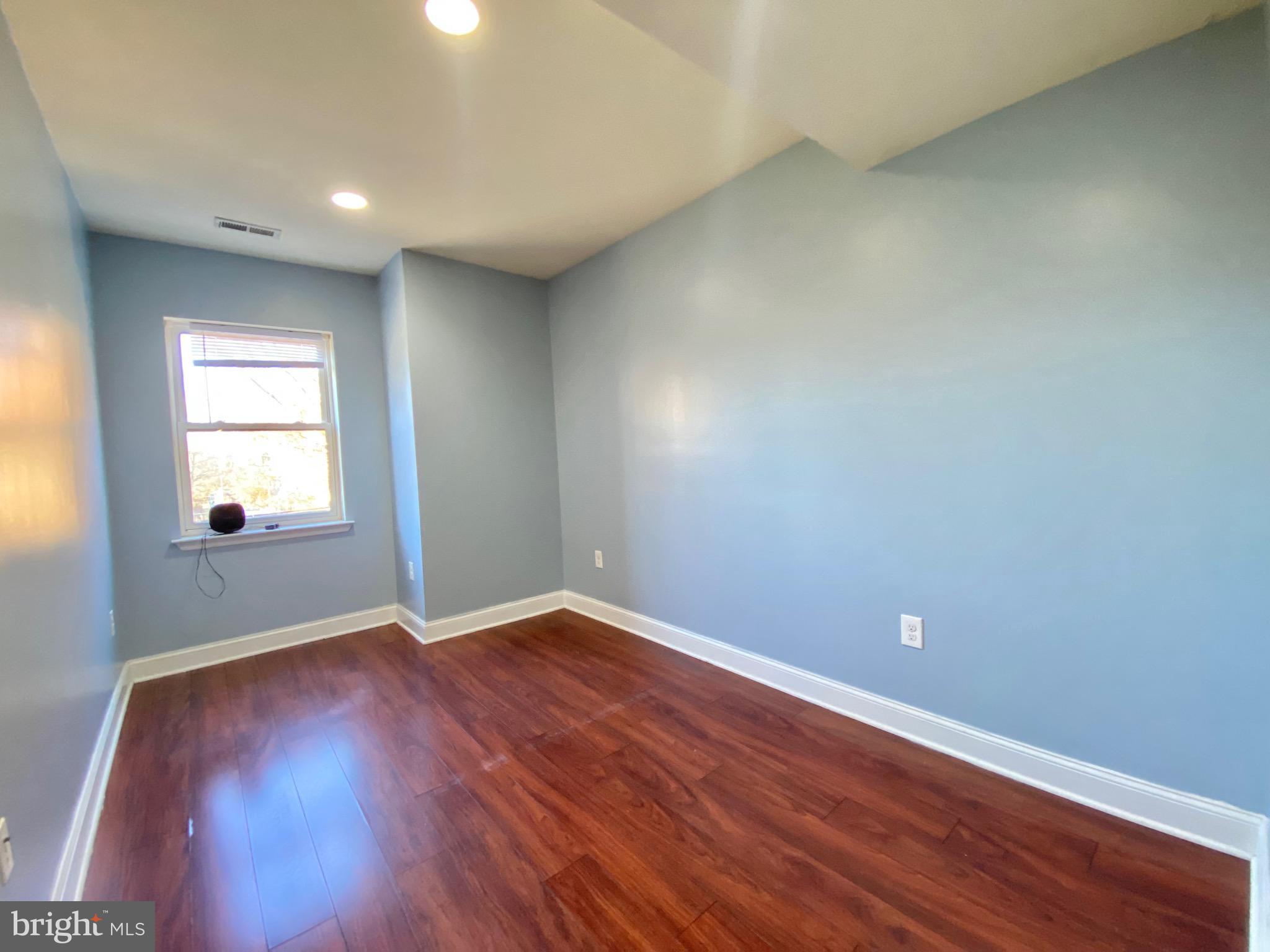 1419 North 17th Street, Unit C Philadelphia, PA 19121 - Photo 15 of 21 an empty room with wooden floor and windows