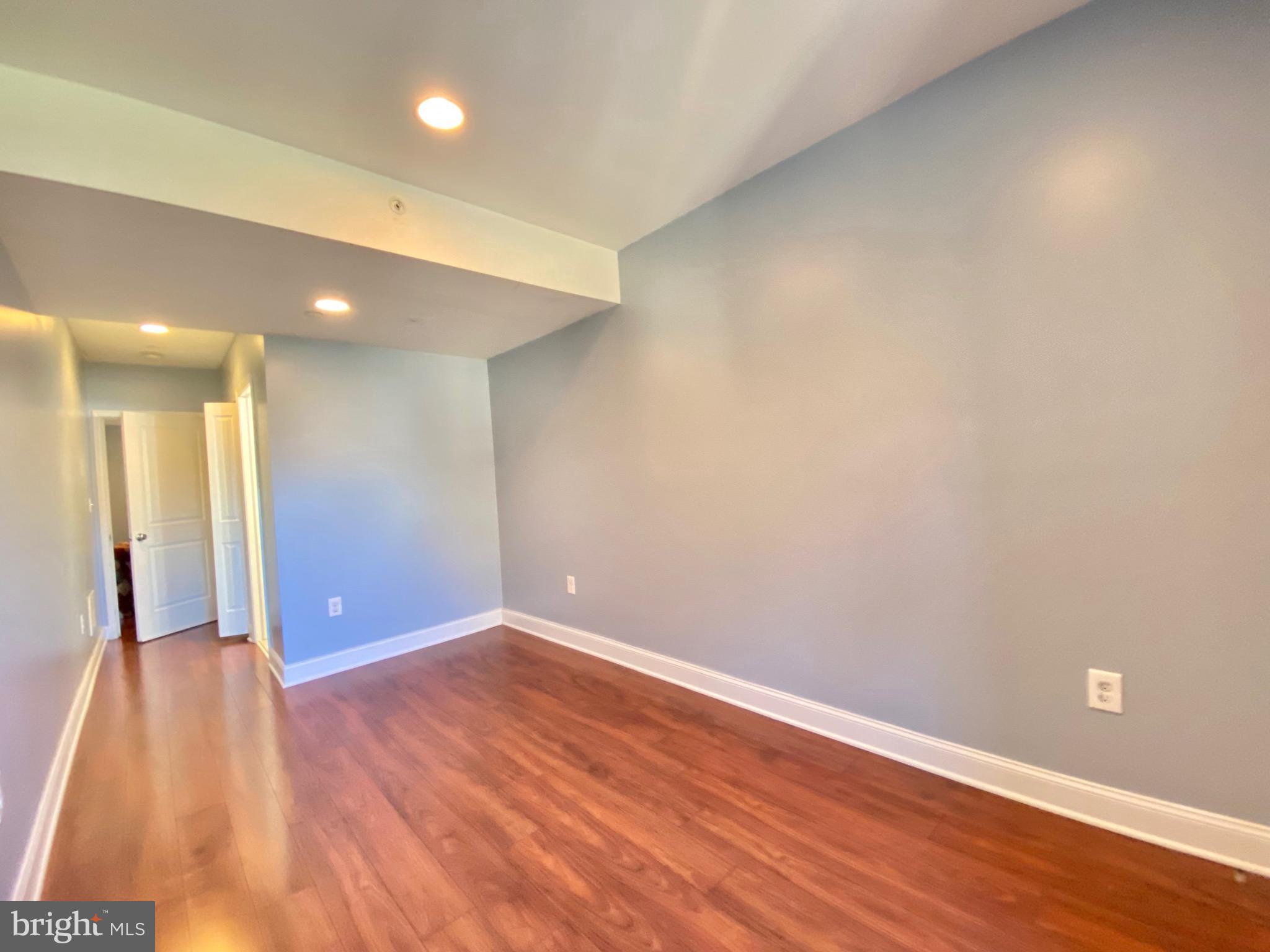 1419 North 17th Street, Unit C Philadelphia, PA 19121 - Photo 19 of 21 an empty room with wooden floor and windows
