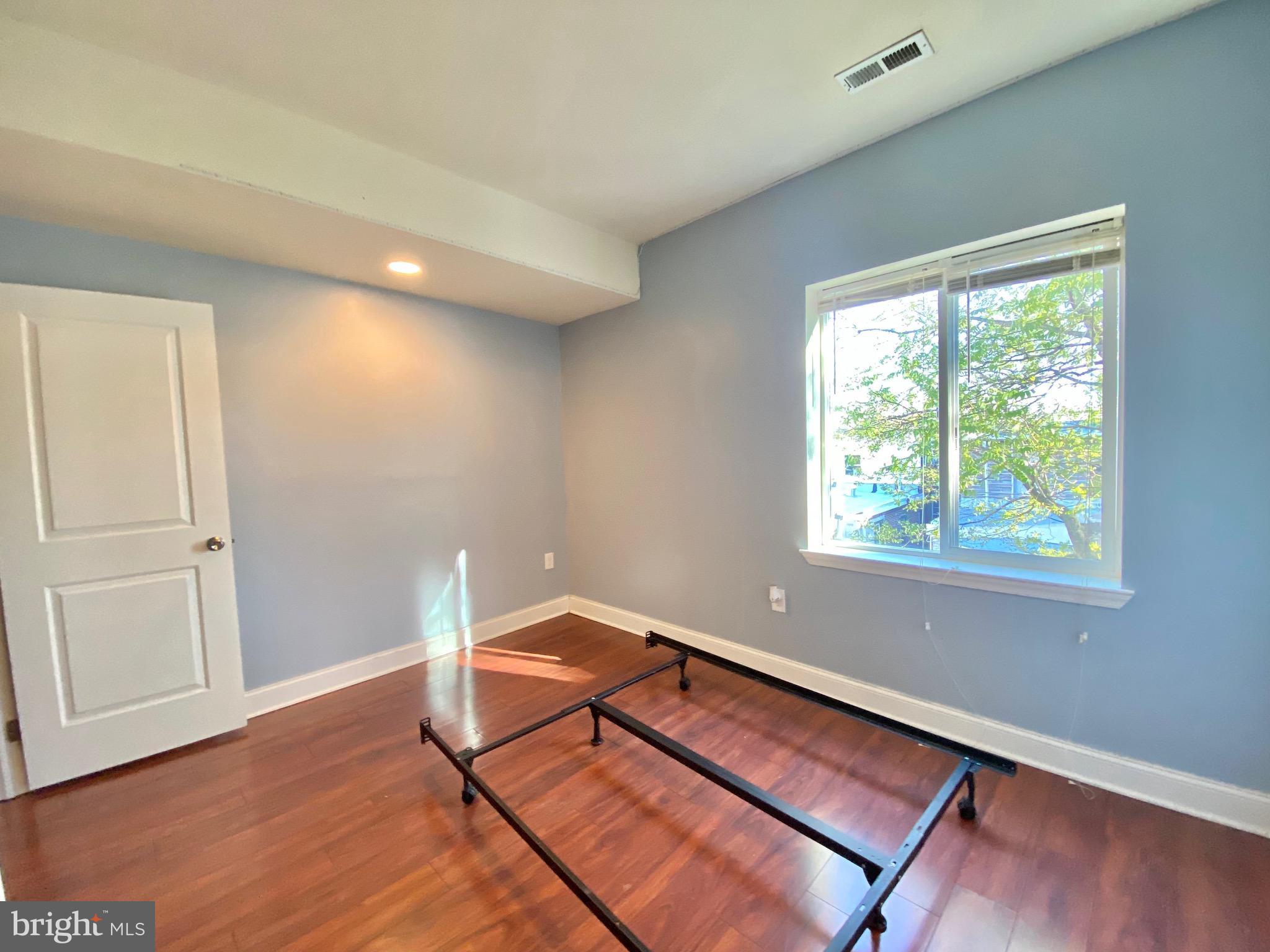 1419 North 17th Street, Unit C Philadelphia, PA 19121 - Photo 8 of 21 a view of an empty room with wooden floor and a window
