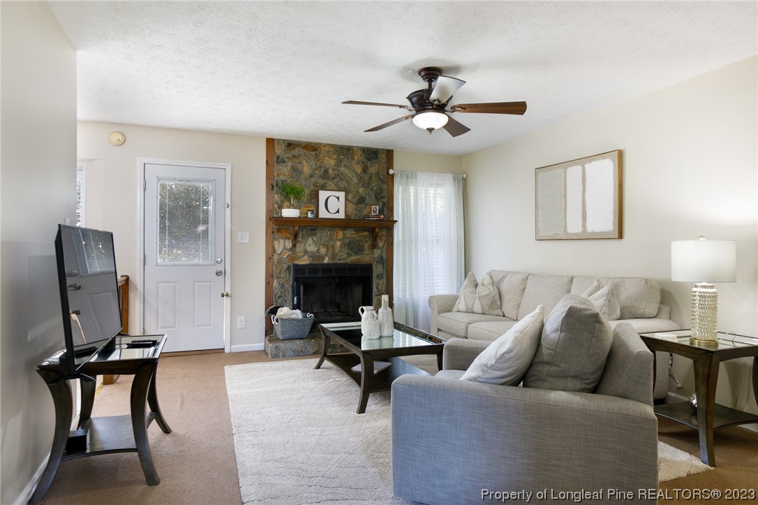 6537 Grist Mill Road Fayetteville, NC 28314 - Photo 11 of 26 a living room with furniture a fireplace and a flat screen tv