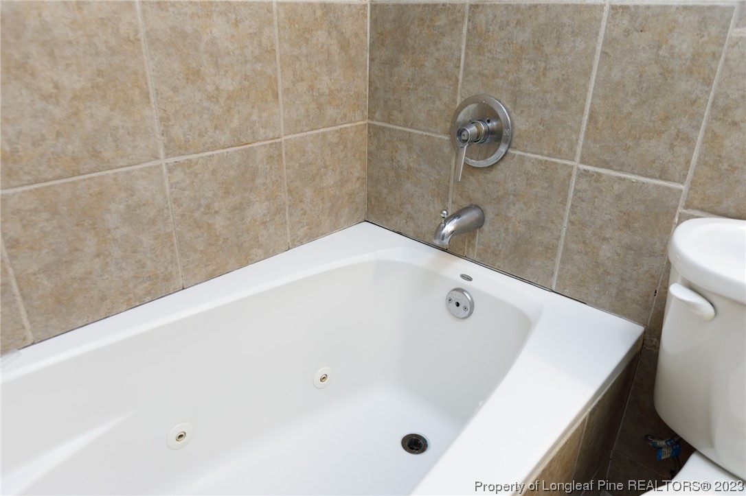 6537 Grist Mill Road Fayetteville, NC 28314 - Photo 17 of 26 a bathroom with a white bath tub and a shower