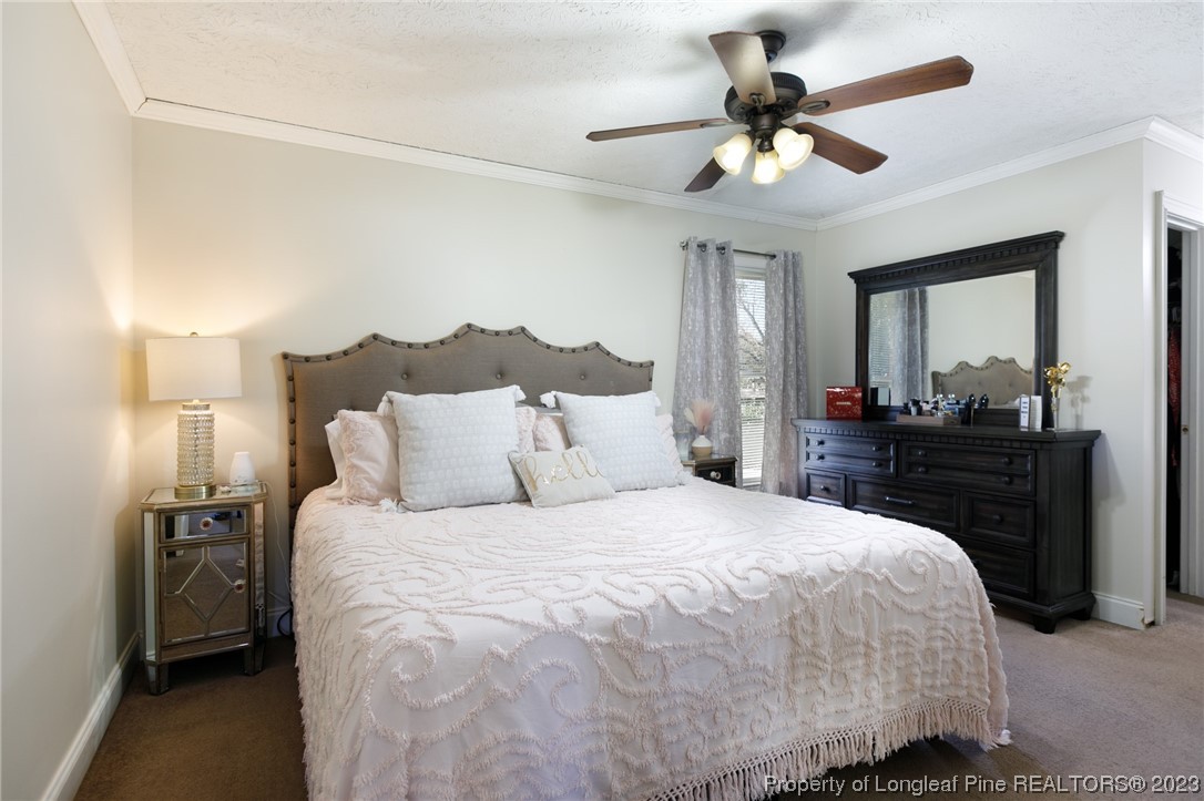 6537 Grist Mill Road Fayetteville, NC 28314 - Photo 18 of 26 a bedroom with a bed and a chandelier