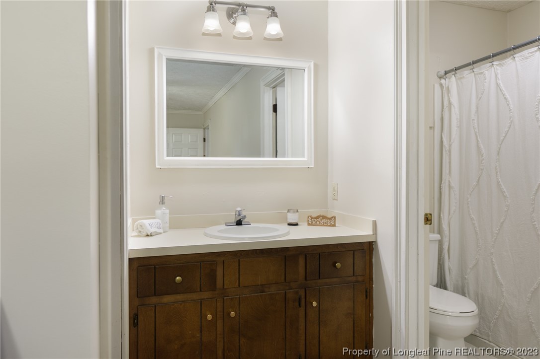 6537 Grist Mill Road Fayetteville, NC 28314 - Photo 20 of 26 a bathroom with a toilet sink and mirror