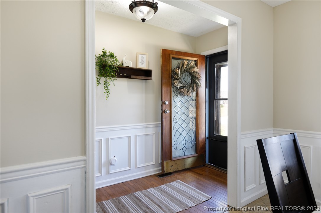 6537 Grist Mill Road Fayetteville, NC 28314 - Photo 4 of 26 a view of a hallway with wooden floor and a potted plant