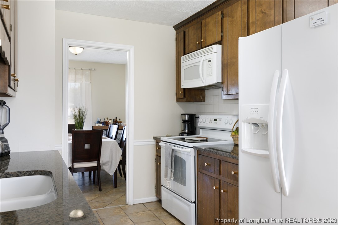 6537 Grist Mill Road Fayetteville, NC 28314 - Photo 6 of 26 a kitchen with stainless steel appliances white cabinets and wooden floor
