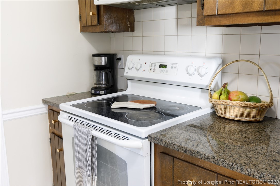 6537 Grist Mill Road Fayetteville, NC 28314 - Photo 7 of 26 a kitchen with granite countertop a sink a stove and cabinets