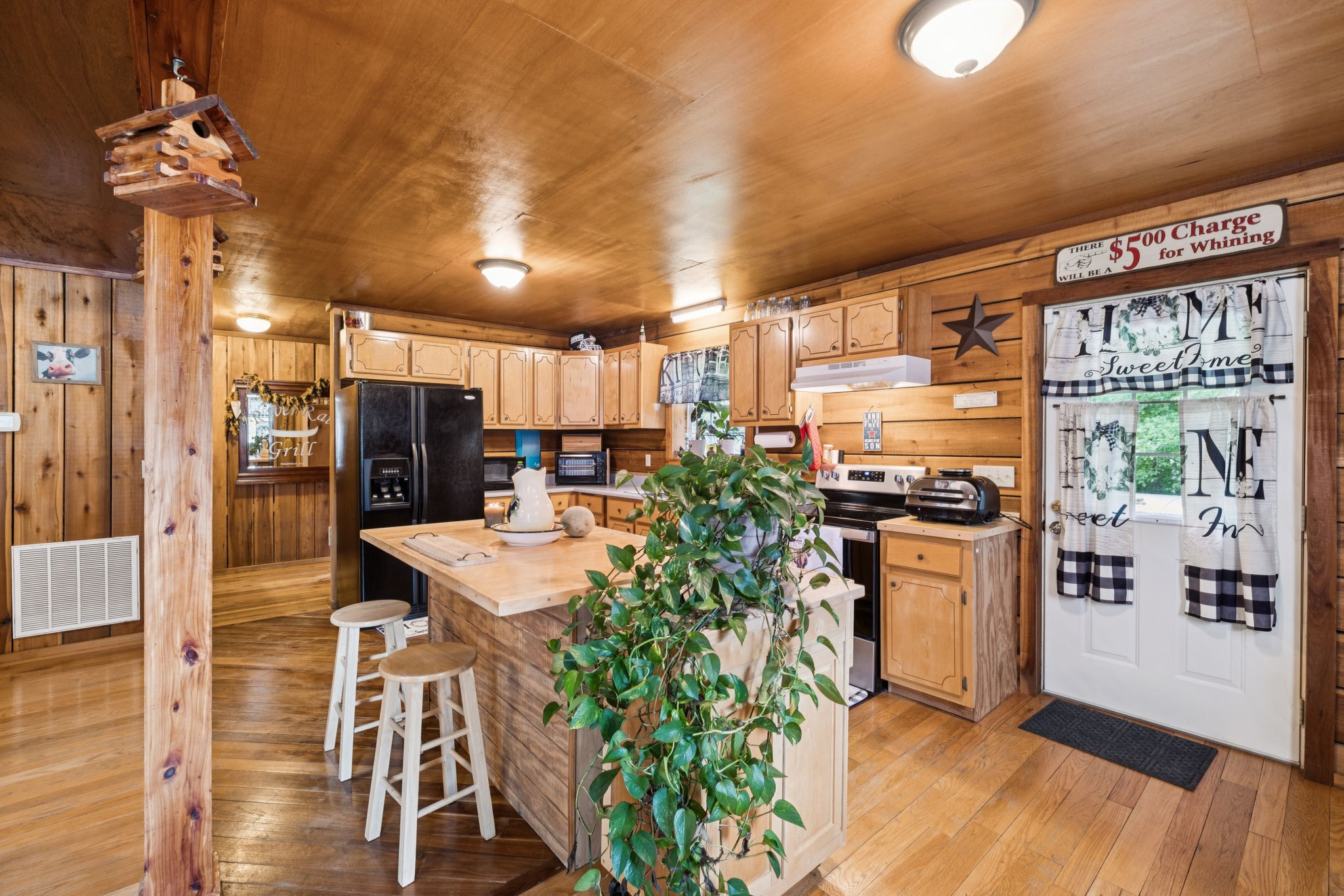 176 Robert Hensley Road Hohenwald, TN 38462 - Photo 16 of 87 a kitchen with stainless steel appliances kitchen island granite countertop a refrigerator a stove top oven and a dining table with wooden floor
