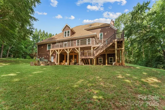 a view of a big house with a big yard and large trees