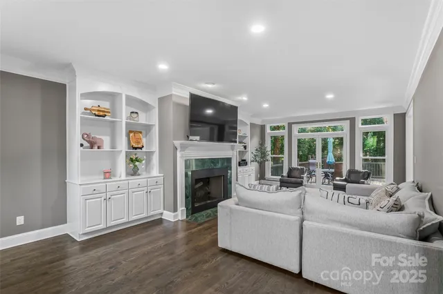 a living room with furniture a fireplace and a large window
