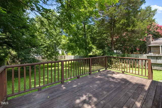 a view of a house with a wooden deck and furniture