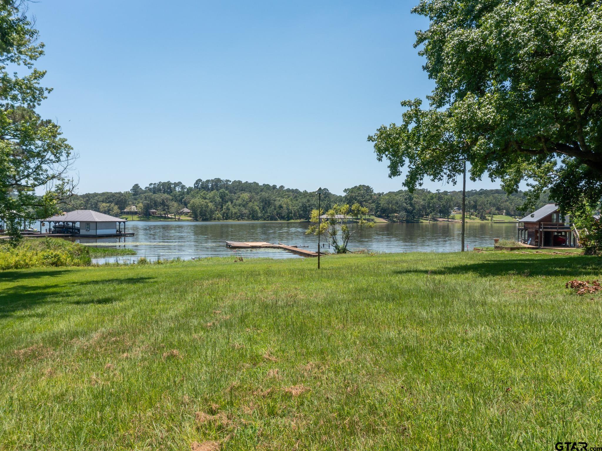15606 McElroy Road Whitehouse, TX 75791 - Photo 10 of 37 a view of a lake with a yard and large trees