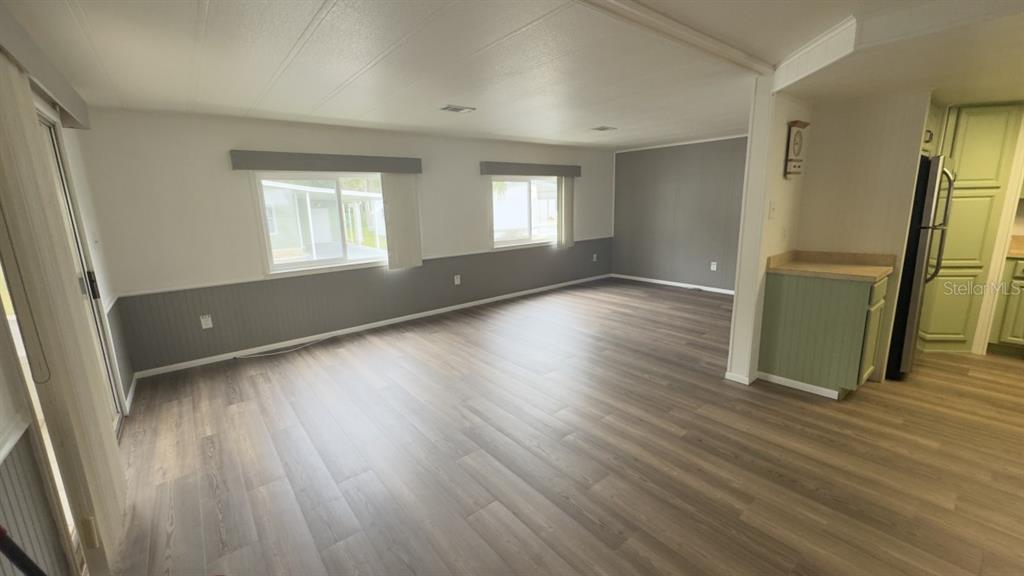 10928 Federal Drive Port Richey, FL 34668 - Photo 4 of 12 an empty room with wooden floor and a window
