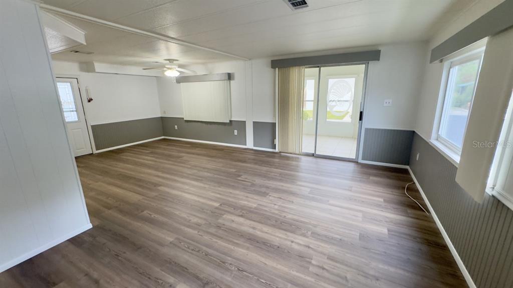 10928 Federal Drive Port Richey, FL 34668 - Photo 5 of 12 an empty room with wooden floor and windows