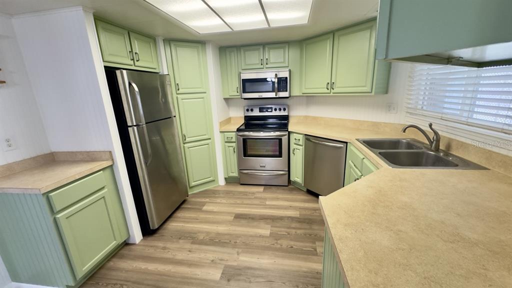 10928 Federal Drive Port Richey, FL 34668 - Photo 6 of 12 a kitchen with granite countertop a refrigerator and a sink