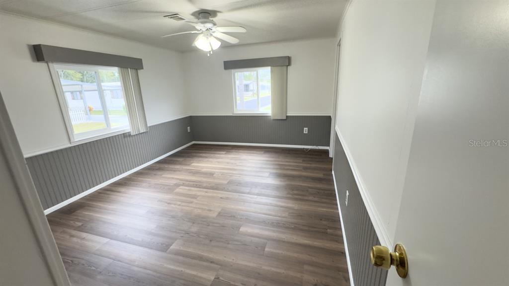 10928 Federal Drive Port Richey, FL 34668 - Photo 10 of 12 wooden floor in an empty room with a window
