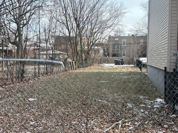 a view of a yard with a house and wooden fence