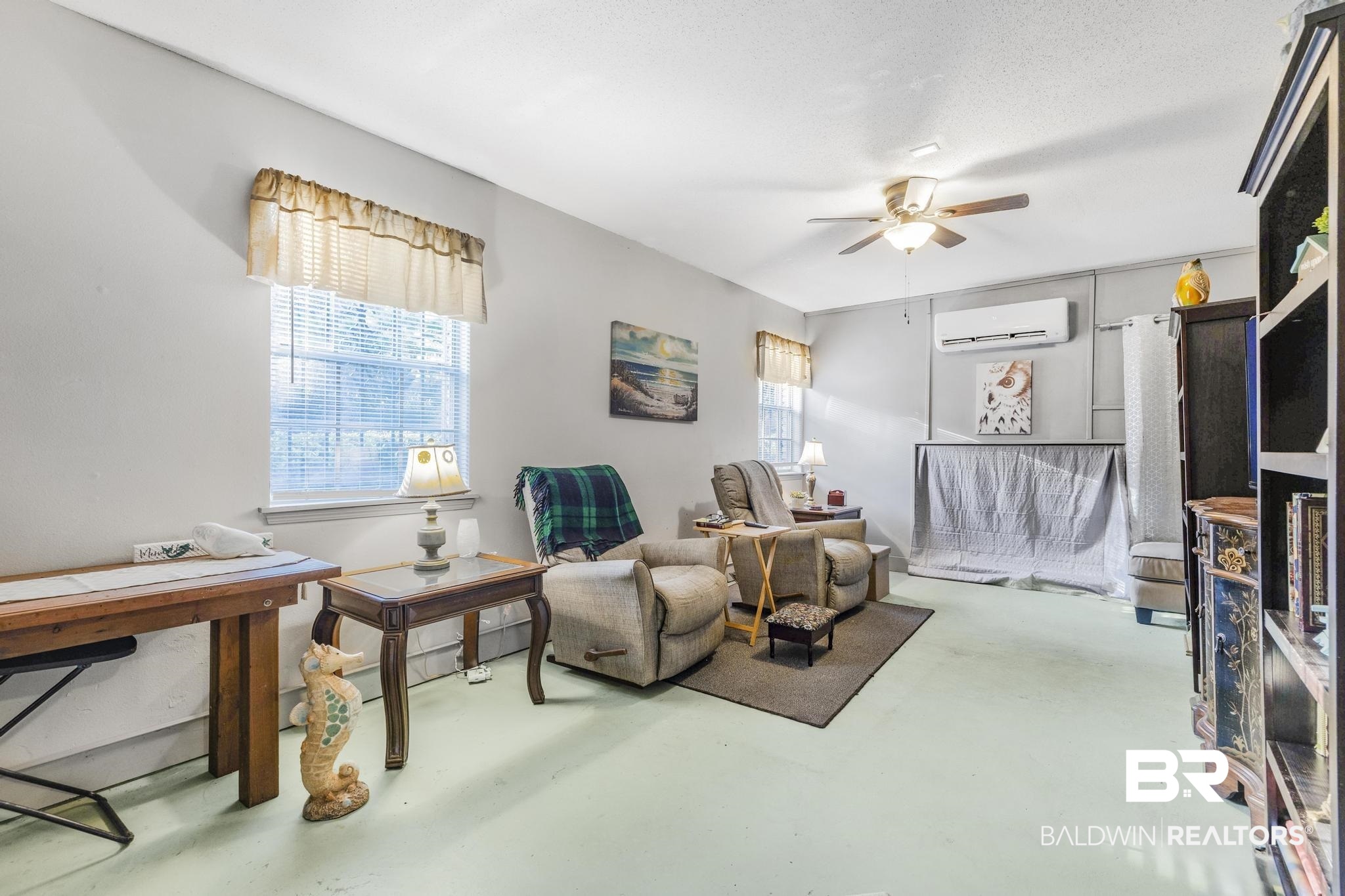 2573 E Road Mobile, AL 36693 - Photo 24 of 45 Living area with finished concrete flooring, a ceiling fan, a wall mounted AC, and a baseboard radiator