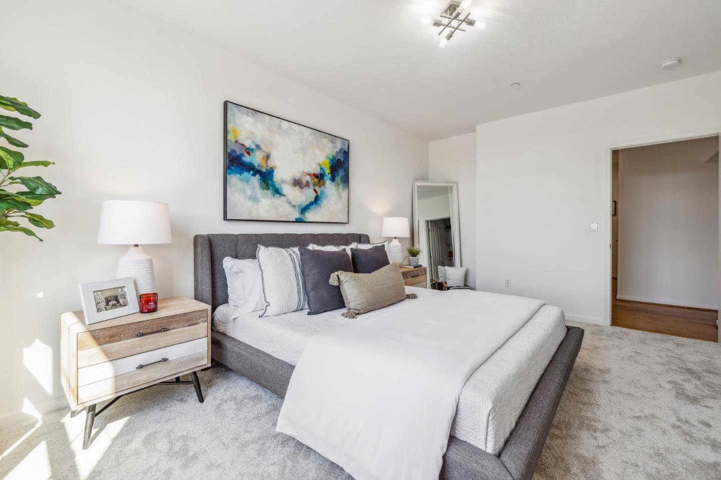 1388 Broadway, Unit 209 Millbrae, CA 94030 - Photo 18 of 40 a bed room with a bed and a painting on the wall