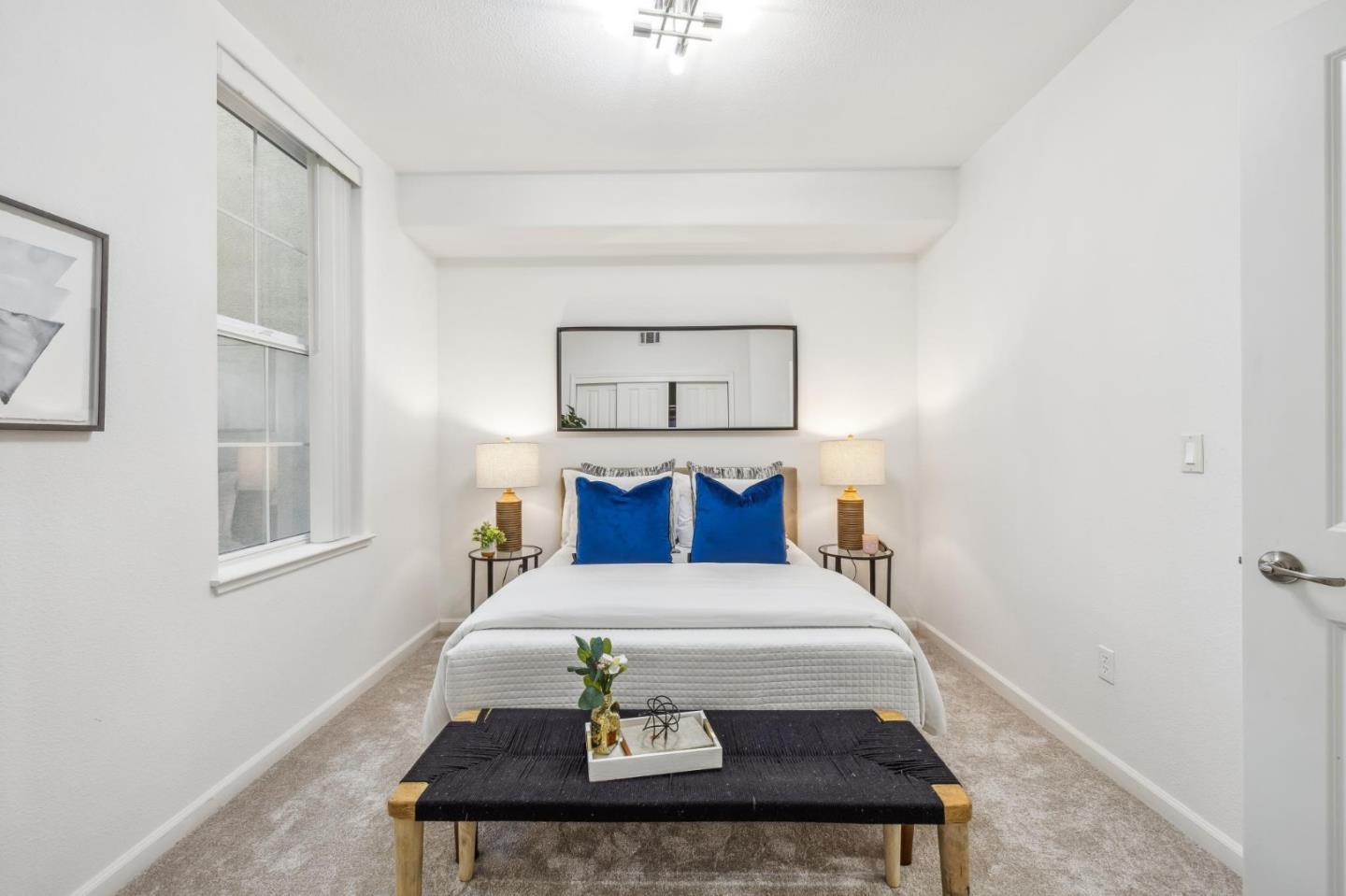 1388 Broadway, Unit 209 Millbrae, CA 94030 - Photo 30 of 40 a bed sitting in a bedroom next to a bathroom with a sink