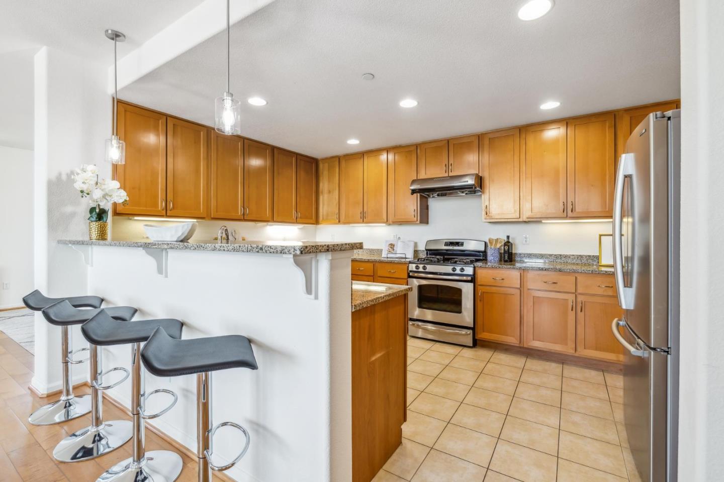1388 Broadway, Unit 209 Millbrae, CA 94030 - Photo 7 of 40 a kitchen with a stove a sink and a refrigerator